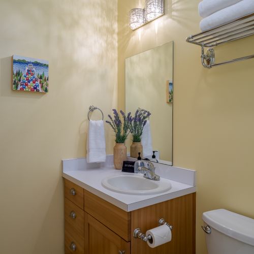 A convenient half bath with a modern vanity, fresh towels, and essential amenities—perfect for added comfort during your stay.