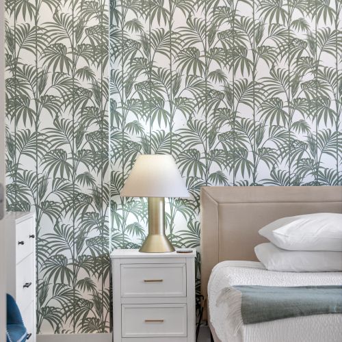 Palm-print accent wall and a soft lamp glow