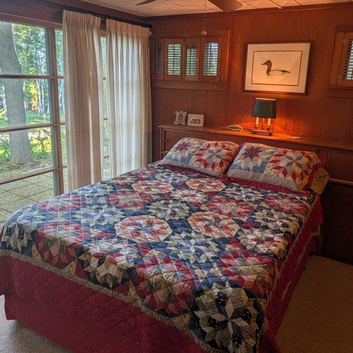 BEDROOM #1 (MAIN FLOOR):  Features a great view of Crystal Lake, queen-size bed, closet, dresser, and a televison.