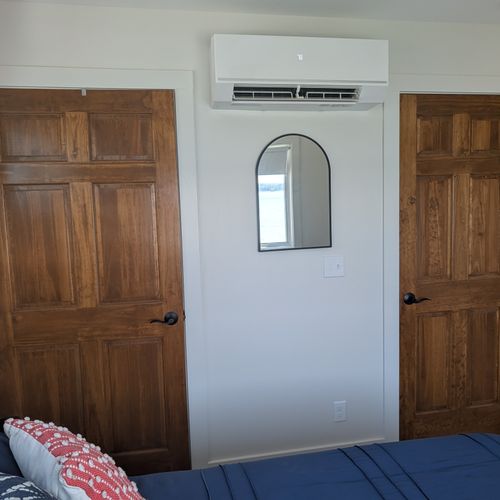 BEDROOM #1 (SECOND FLOOR):  Features a queen-size bed, nightstands, lamps, ceiling fan, mini-split A/C unit, television, dresser, closet, mirror, and a great view of Crystal Lake!