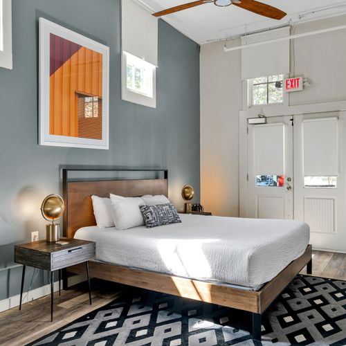 Iron and wood bed under vibrant orange art