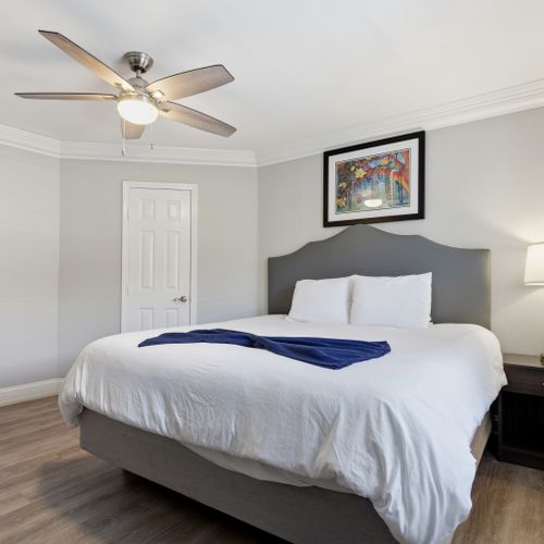 Unit 207 primary bedroom — peaceful retreat w/ a king bed & soft neutral tones.