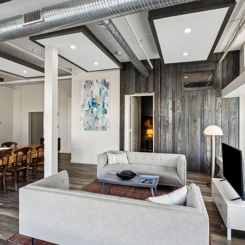 Cozy living space w/ sofa, art & wood-plank accent wall.