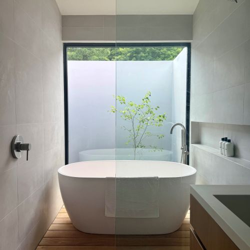 Soak in the spa-inspired bath, where a freestanding tub frames a private garden view.