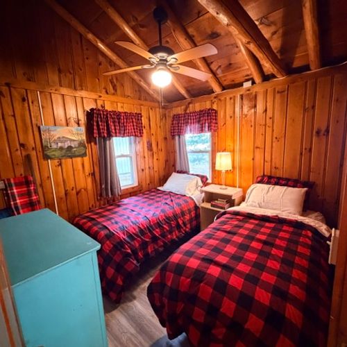 BEDROOM #3:  Features two single beds, a nightstand with a lamp, ceiling fan, and a dresser.