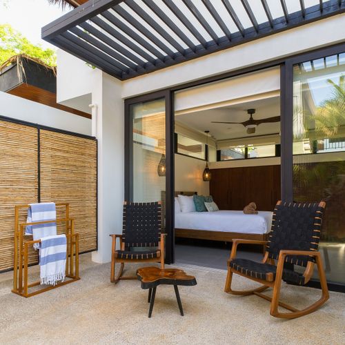 Private guest suite at Casa Oso with sliding glass entry, outdoor shower and rocking-chair patio, Tamarindo, Costa Rica.