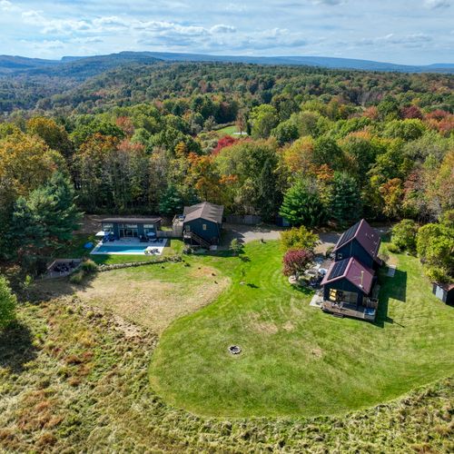 Three buildings across five private acres, featuring a pollinator meadow, heated pool, hot tub, outdoor shower, two grills and fire pit.