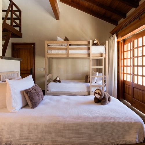 Family-friendly bunk room with full bed, bunk beds and upstairs sleeping loft at Casa Libelula luxury beachfront estate, Tamarindo.