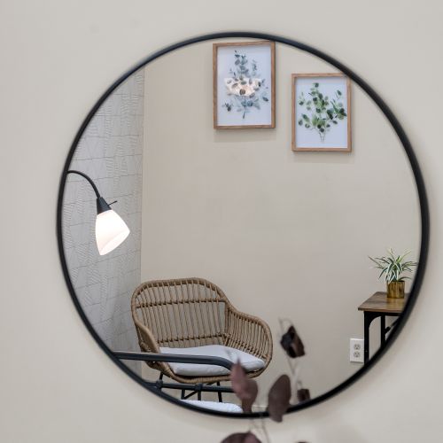 Round mirror reflecting a cozy reading spot