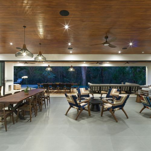 Open-concept great room with chef kitchen, dining for 10 and multiple lounges open to the pool deck at dusk, Casa Oso, Tamarindo.