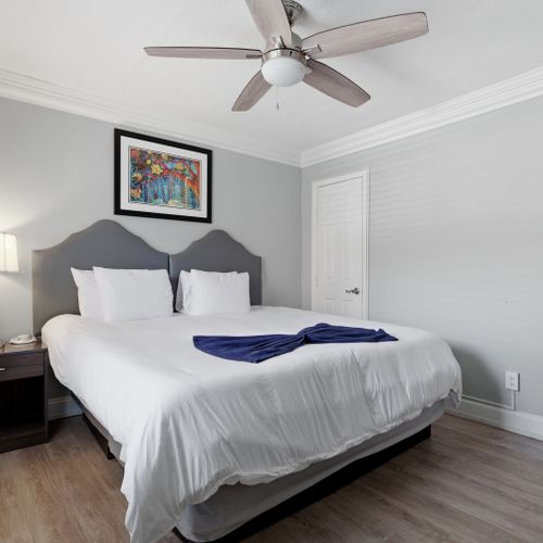Calm & comfortable bedroom w/ a bed dressed in crisp white linens.