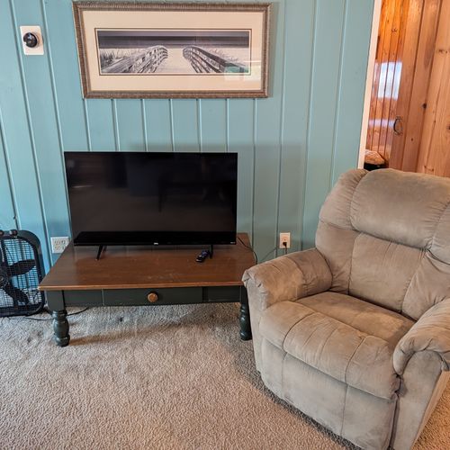 LIVING ROOM:  Large and comfy living room with a sofa, comfy chair, 2 futons, a coffee table, streaming television, and window A/C unit.