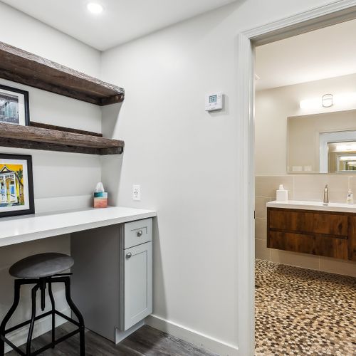 Cute vanity nook w/ sink, wood shelving & décor touches.