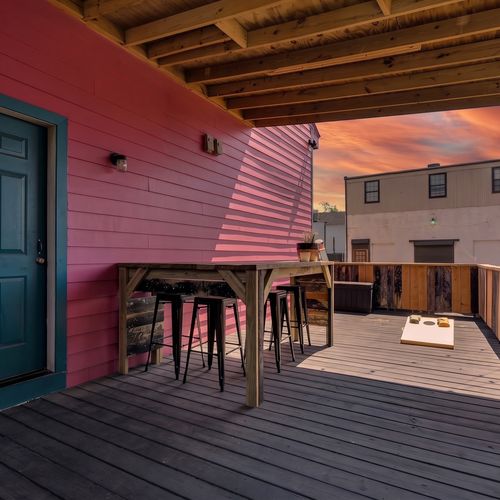 Colorful deck w/ bar seating & cornhole — your go-to spot for laid-back hangs.