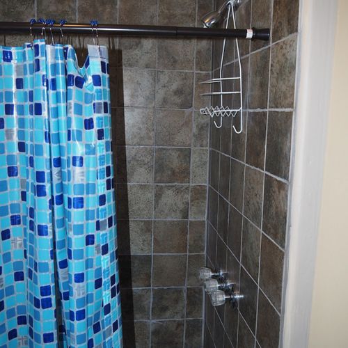 The bathroom is Cabin #10 features a shower and a toilet.  (Note that there is no vanity, sink, or mirror in the bathroom.)