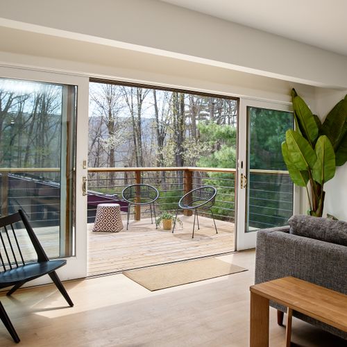 Oversized sliding glass doors open onto the guest house deck on the second story, overlooking the pool.