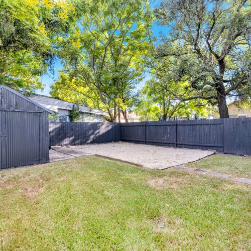 Let the kids or pup roam in the fenced backyard w/ lush green grass under leafy shade trees