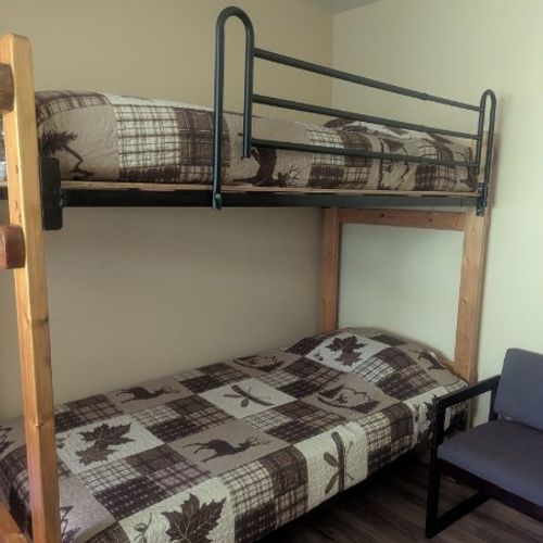 MAIN ROOM:  Includes two twin-on-twin bunk beds, a small dining table, chairs, and a kitchenette / sink.