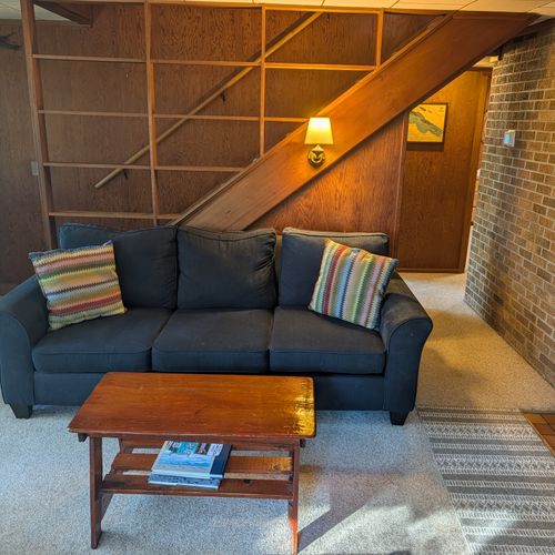 MAIN LIVING ROOM (FIRST FLOOR):  The home has a large, cozy, and comfortable living room on the main floor.  Note that the wood fireplace is available for guest usage.