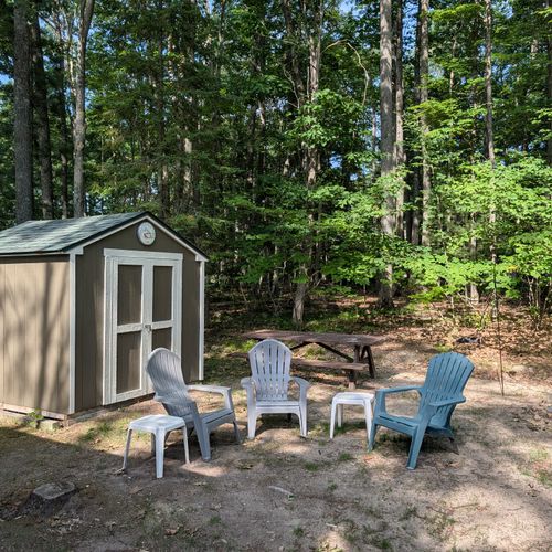 EXTERIOR:  The fun and family-friendly backyard with a picnic table, Adirondack chairs, and tables