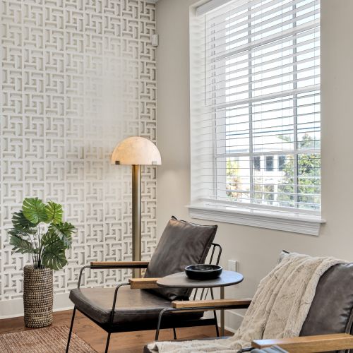 Reading chair tucked beside textured wallpaper