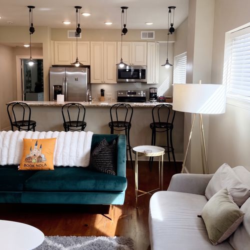 Living area w/ teal velvet sofas & warm hardwood floors for easy lounging