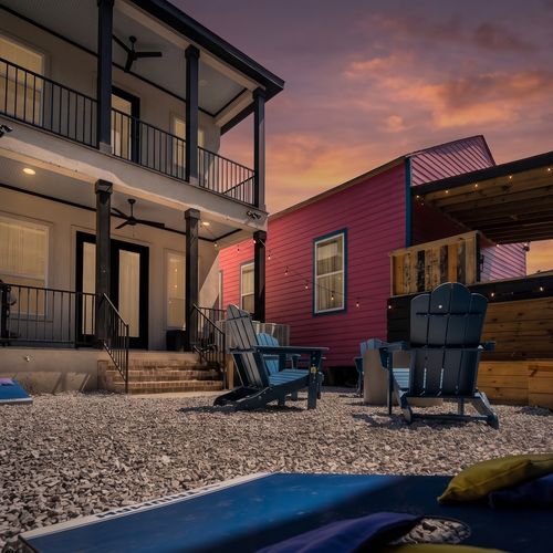 Backyard setup w/ cornhole, firepit & colorful surroundings for the whole group.