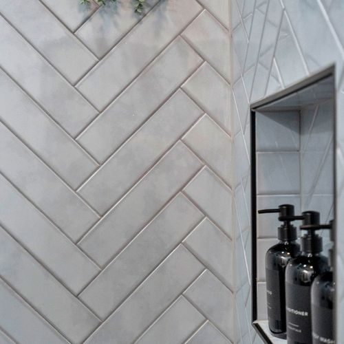Modern herringbone tile & sleek black accents give the bathroom a spa-like feel