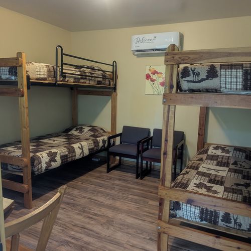 MAIN ROOM:  Includes two twin-on-twin bunk beds, a small dining table, chairs, and a kitchenette / sink.