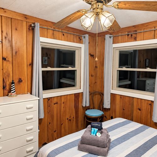 BEDROOM #2:   Features a queen-size bed, nightstands, lamp, dresser, closet, and chair.