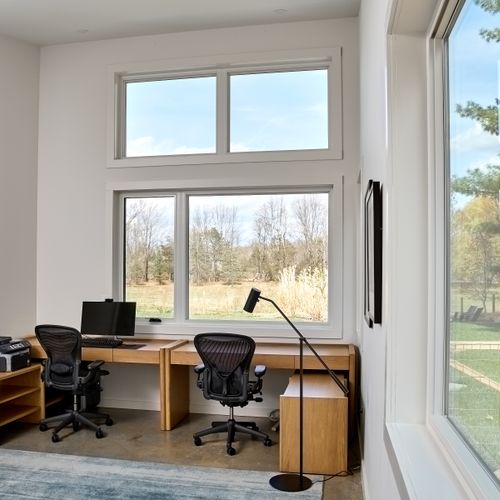 This dedicated work space for remote work has a monitor, printer and peaceful views looking out onto the meadow.