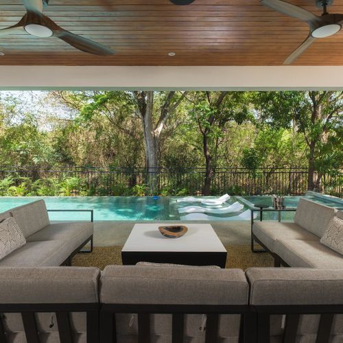 U-shaped sectional in the great room of Casa Oso with retractable glass walls open to the courtyard staircase, Tamarindo, Costa Rica.