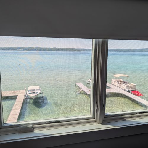 BEDROOM #3 (THIRD FLOOR):  Features a king-size bed, private mini-split A/C unit, ceiling fan, nightstands, reading lamps, chair, television, dresser, closet, private bathroom entrance, and spectacular views of Crystal Lake!
