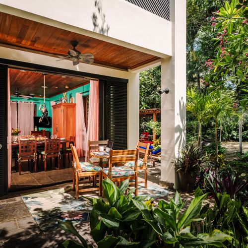 Side terrace with BBQ grill and outdoor dining table connected to indoor dining area at this luxury villa Tamarindo. Seamless indoor-outdoor flow, tropical garden views, perfect for al fresco meals and entertaining guests near Langosta beach.