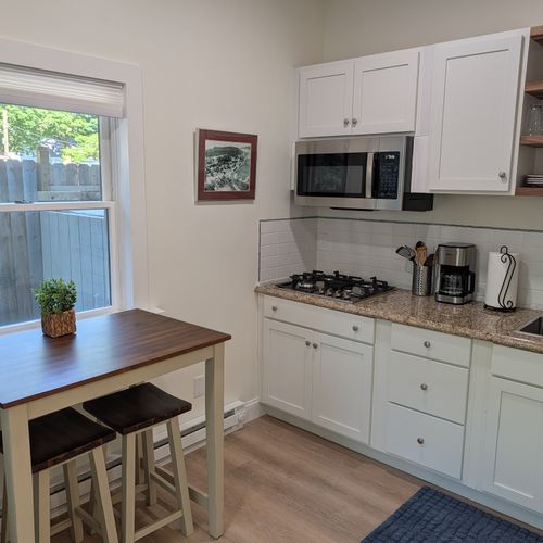 KITCHEN: The apartment's cute kitchen with a stove, microwave, coffeemaker, refridgerator, and other kitchen essentials. Perfect for cooking! The cute dining table to the left offers a place to eat