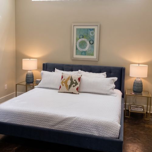 Airy bedroom w/ crisp white bedding & soft bedside lighting