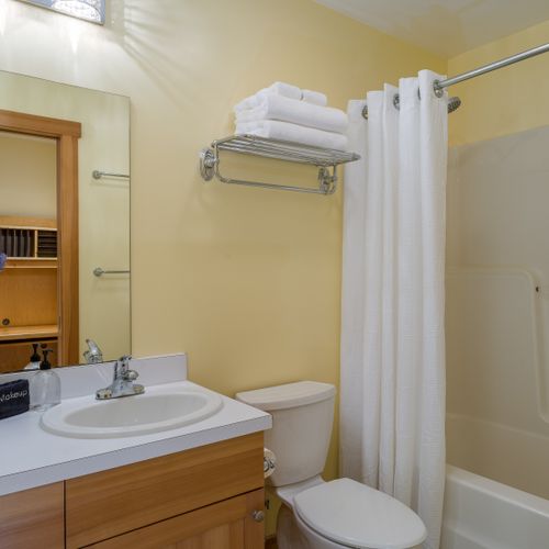 A clean, bright full bathroom with a shower/tub combo, fresh towels, and complimentary essentials for a relaxing stay.