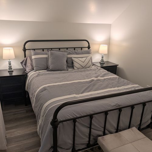 BEDROOM #1 (SECOND FLOOR):  Features a queen-size bed, nightstands, lamps, dresser, mirror, closet, and ceiling fan.