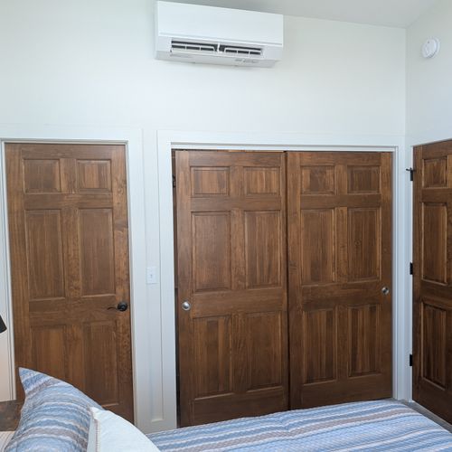 BEDROOM #3 (THIRD FLOOR):  Features a king-size bed, private mini-split A/C unit, ceiling fan, nightstands, reading lamps, chair, television, dresser, closet, private bathroom entrance, and spectacular views of Crystal Lake!