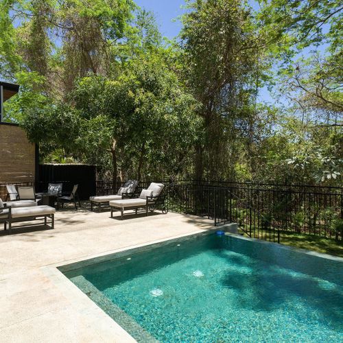 Private pool with chaise lounges and an outdoor firepit surrounded by tropical Guanacaste jungle at Casa Oso luxury villa, Tamarindo.