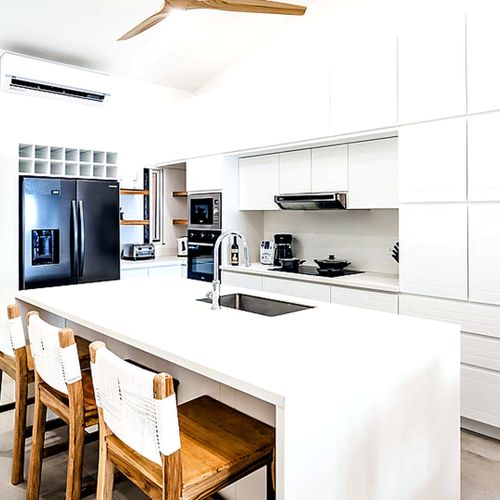 Fully equipped chef's kitchen with a large island, bar seating, and full-size stainless/black appliances