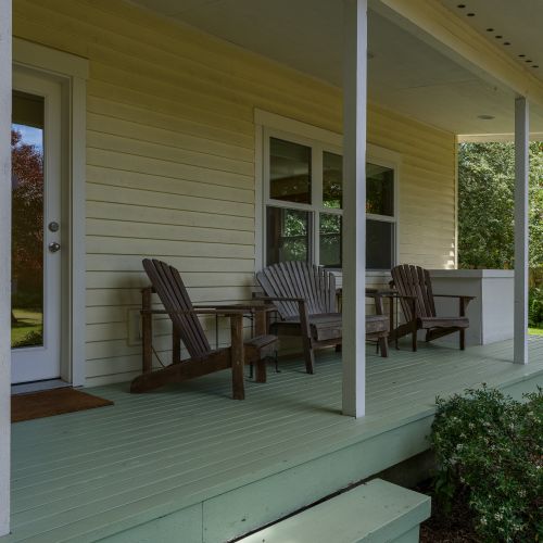 Stretch out on the spacious covered front porch, complete with Adirondack seating and peaceful garden views—an inviting spot to enjoy your morning coffee or unwind after a day of exploring.