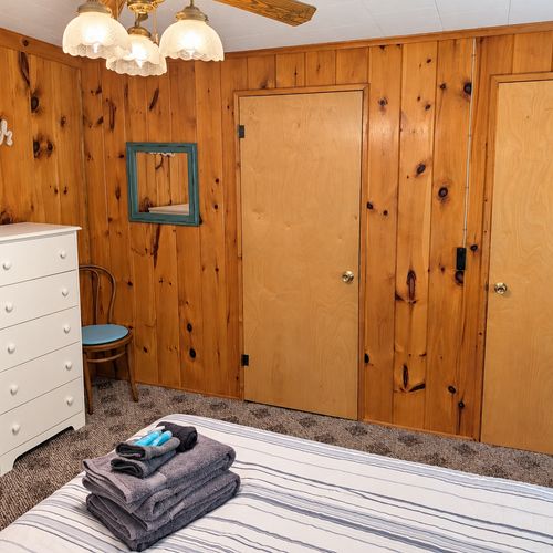 BEDROOM #1:   Features a queen-size bed, nightstands, lamp, dresser, closet, and chair.