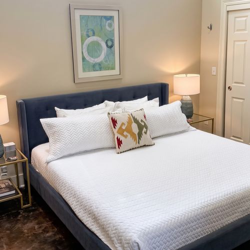 Comfortable bedroom with crisp white bedding and blue accent wall