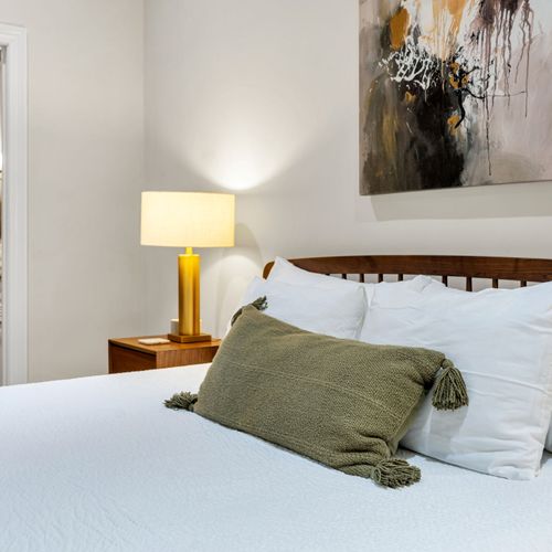 Sage pillows and a warm bedside lamp
