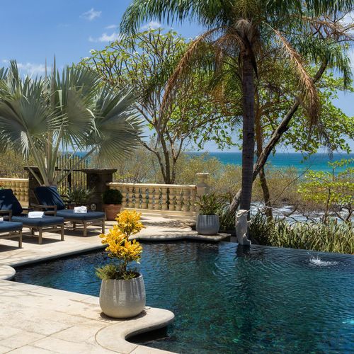 Beachfront pool deck - chaises, palms, and an unobstructed Pacific Ocean view.