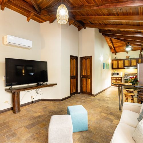 Casita living room — vaulted hardwood ceiling, smart TV, sectional, breakfast bar, kitchenette.