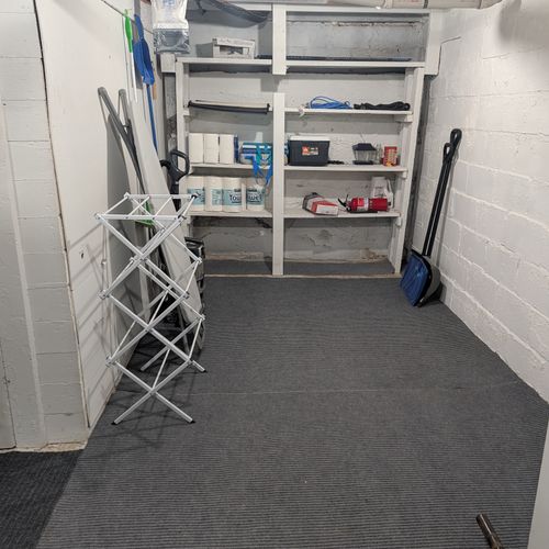 LAUNDRY ROOM (BASEMENT):  Large laundry room in the basement with a top load washer and a dryer.