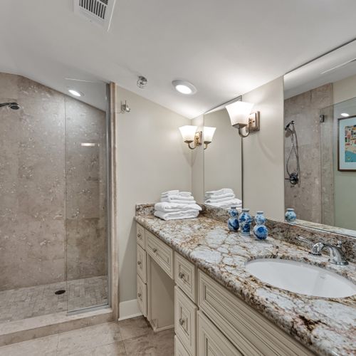 Granite vanity lit by elegant sconces