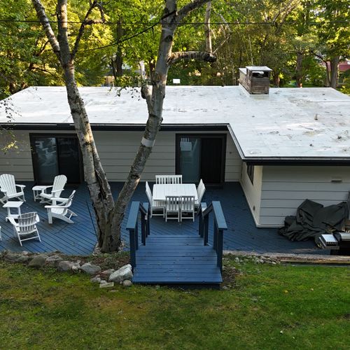 OVERVIEW:  The beautiful backyard deck, featuring a propane grill, outdoor dining furniture, and Adirondack chairs with tables.